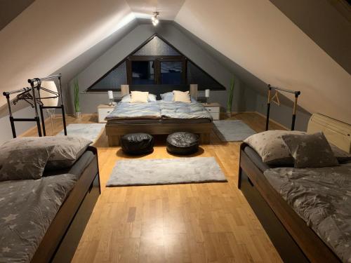 um quarto no sótão com 2 camas e uma janela em Apartmány City 2 em Ostrava