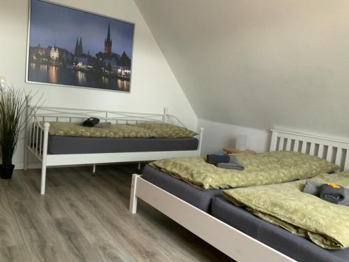a bedroom with two beds and a picture on the wall at Ferienhaus Annu in Lensahn