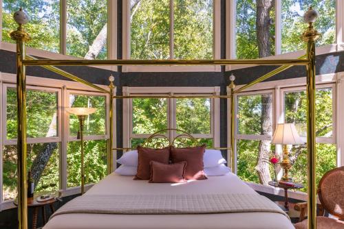 a bedroom with a canopy bed in front of a window at Arsenic and Old Lace Bed & Breakfast Inn in Eureka Springs
