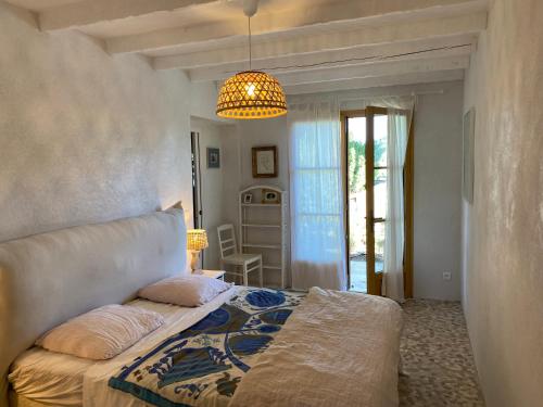 a bedroom with a bed and a chandelier at Lovely "Provence" villa with sea view, private heated pool, airco and beautiful garden in Grimaud