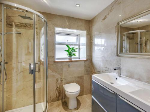 a bathroom with a toilet and a shower and a sink at Beechfield in Harrogate