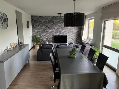 a dining room with a table and a couch at Maison Noordburg Veurne in Veurne