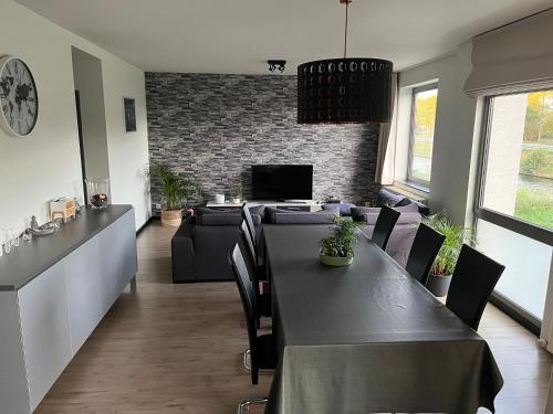 uma sala de jantar com uma mesa e um sofá em Maison Noordburg Veurne em Veurne