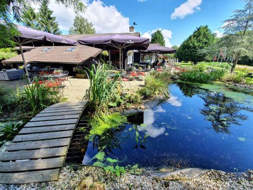 a wooden bridge over a pond in front of a house at Scandinavisch dorp in Eelderwolde