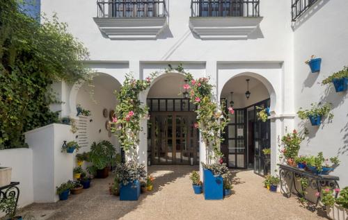 a courtyard with potted plants in front of a building at Ilunion Hacienda de Mijas in Mijas