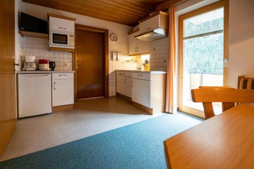 a small kitchen with white appliances and a window at Apart Harmonie in Kappl