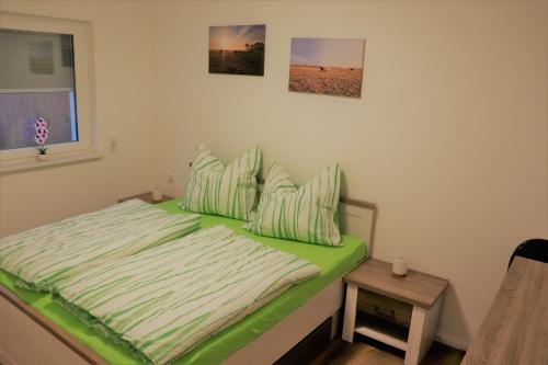 uma cama com um edredão verde num quarto em Naturferienhof Märkisch Luch 