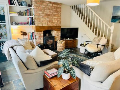 ein Wohnzimmer mit 2 Sofas und einem Kamin in der Unterkunft Idyllic Country Cottage near Soho, Oxford & Cotswolds in Banbury