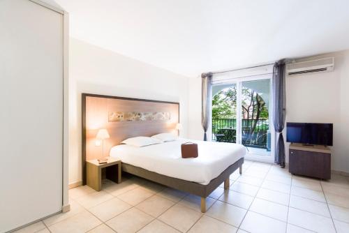 - une chambre avec un lit et une grande fenêtre dans l'établissement Garden & City Aix En Provence - Rousset, à Rousset