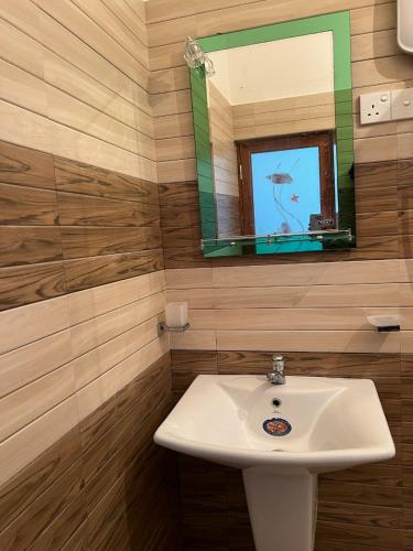 a bathroom with a sink and a mirror at Plantation Inn in Weligama