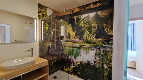 a bathroom with a painting of a pond at Kittenberger Chalets am Gartensee in Schiltern