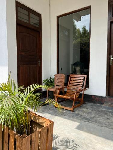 two chairs sitting on the porch of a house at Plantation Inn in Weligama