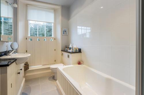 a bathroom with a tub and a toilet and a sink at Maple Tree View in Totnes