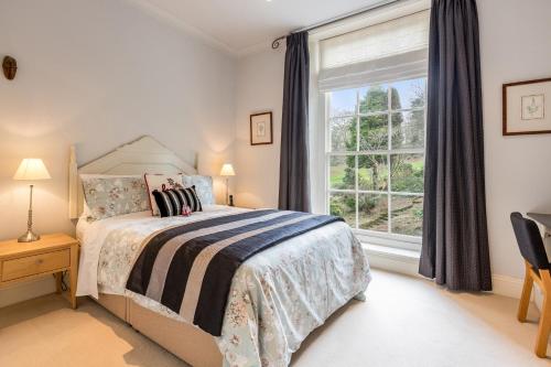 um quarto com uma cama e uma grande janela em Maple Tree View em Totnes