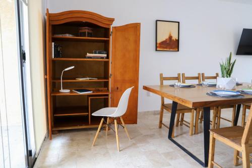 a dining room with a table and a book shelf at Casa en hermoso condominio, 10 personas! in San Miguel de Allende