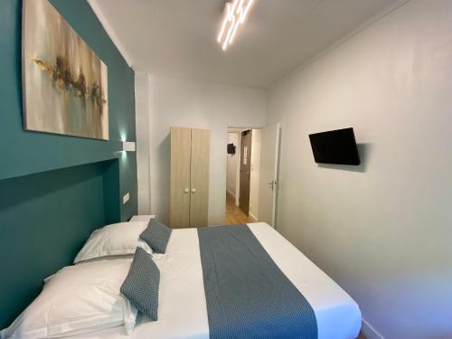 a bedroom with a large bed and a tv at Lyo Hôtel - Centre Lyon Perrache in Lyon