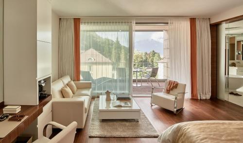 a bedroom with a couch and a living room at Grand Resort Bad Ragaz in Bad Ragaz