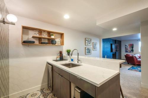 a kitchen with a sink and a living room at Modern Apartment close to freeway! in Salt Lake City