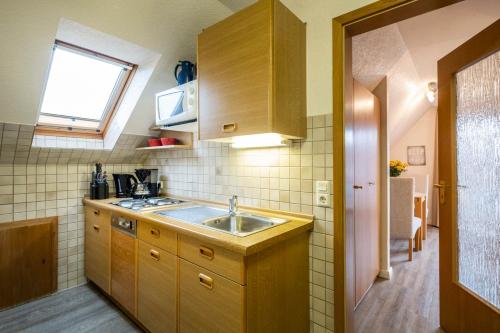 een kleine keuken met een wastafel en een raam bij Haus Kähler 1 Wohnung 7 in Büsum
