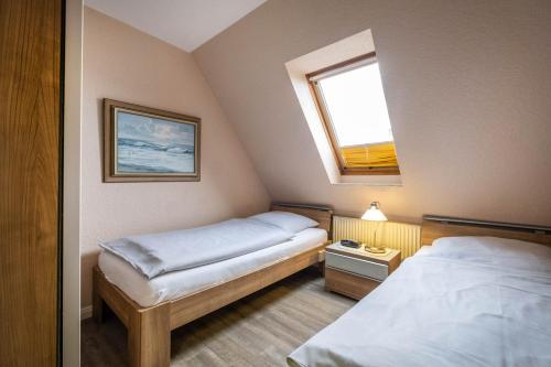een kleine kamer met 2 bedden en een raam bij Haus Kähler 1 Wohnung 7 in Büsum