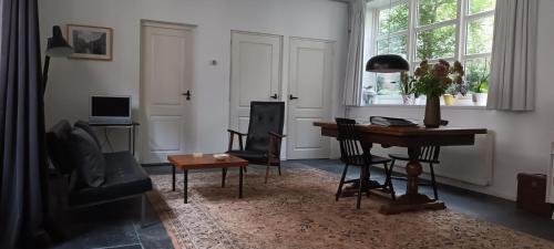 un soggiorno con tavolo, sedie e scrivania di Villa Conti a Dordrecht