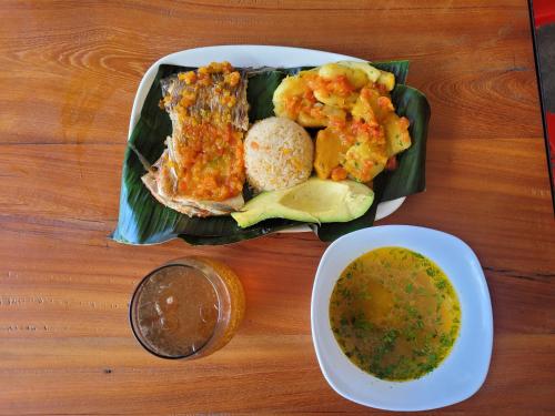 un plato de comida con pescado y un tazón de sopa en Estadero y Hospedaje las Pavas, en Norcasia