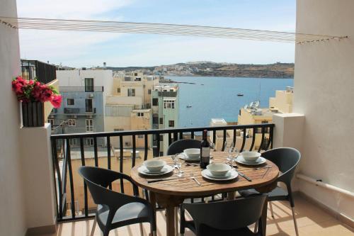 un tavolo su un balcone con vista sull'oceano di Seashells Apartments with terrace, just off the seafront in Bugibba - by Getawaysmalta a San Pawl il-Baħar