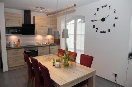 uma cozinha com uma mesa e um relógio na parede em Wellenbrecher em Greetsiel