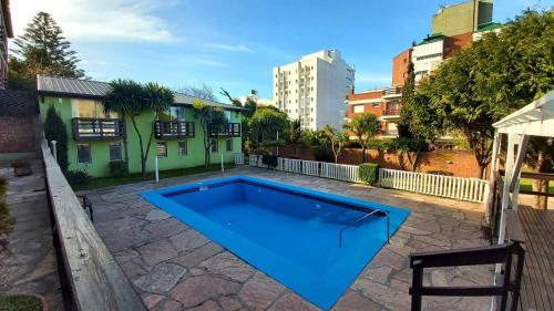 una gran piscina azul en un patio con un edificio en COMPLEJO TRIUMPH en Mar del Plata