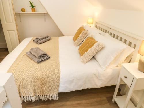 a bedroom with a white bed with towels on it at Alma Cottage in Buxton