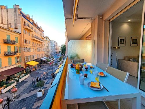 - une table bleue sur un balcon avec de la nourriture dans l'établissement Nestor&Jeeves - ANGLICAN TERRASSE - Central - Very close sea, à Nice
