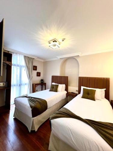 a hotel room with two beds and a window at Dakani Hotel Boutique NEW in Quito
