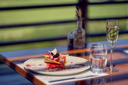 a plate of food on a table with a wine glass at Minthis Resort in Paphos City