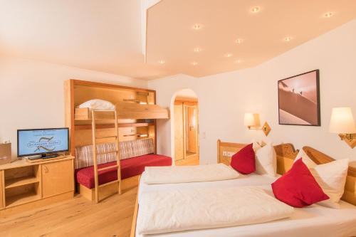 ツァウヘンゼーにあるHotel Zauchensee Zentralのベッドルーム1室(ベッド2台、二段ベッド1組付)