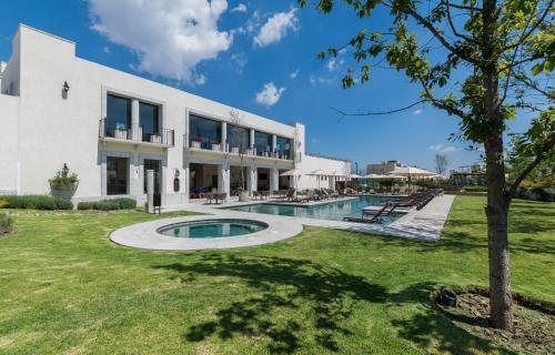 an exterior view of a white building with a swimming pool at Casa en hermoso condominio, 10 personas! in San Miguel de Allende