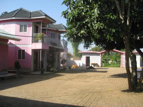 a group of pink houses with a brick courtyard at R&R Gardens Hotel in Mbale