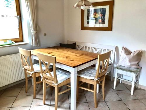 a dining room table with chairs and a wooden table at Seehäuschen - Waging Tettenhausen in Waging am See