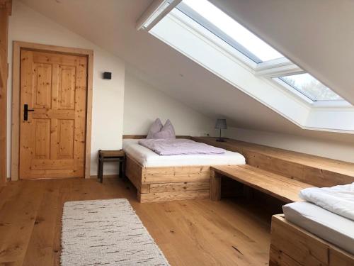 a attic bedroom with two beds and a skylight at Seehäuschen - Waging Tettenhausen in Waging am See