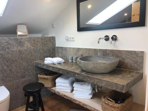 濱湖瓦京的住宿－Seehäuschen - Waging Tettenhausen，浴室配有盥洗盆和带毛巾的台面。