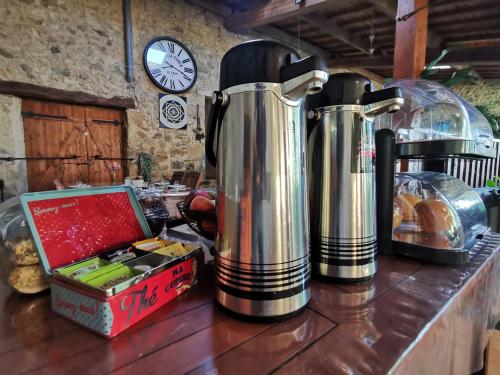 Twee grote metalen waterkokers op een aanrecht met een klok. bij Atelier du Philosophe in Saint-Victor