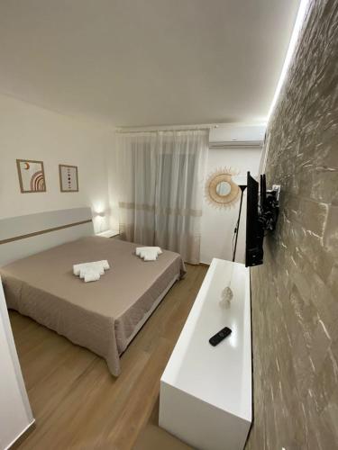 um quarto com duas camas e uma mesa e uma televisão em Dimora Garibaldi Apartment & Room em Agrigento