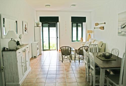 Apartamento con vistas al mar 2 في بورت دي لا سيلفا: مطبخ وغرفة معيشة مع طاولة وكراسي