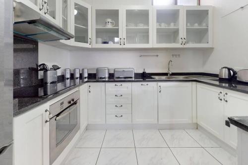 Biała kuchnia z białymi szafkami i zlewem w obiekcie San Lameer 2820 by Top Destinations Rentals w mieście Southbroom