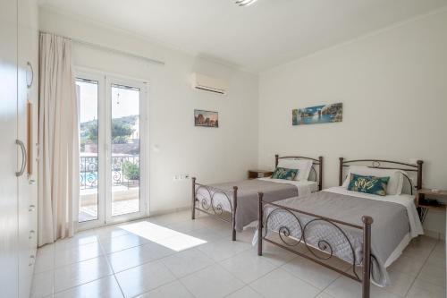 a bedroom with two beds and a balcony at Amina villa in Agios Nikolaos