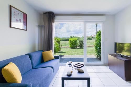 sala de estar con sofá azul y TV en Garden & City Clermont-Ferrand - Gerzat, en Gerzat