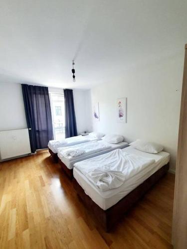 three beds in a room with wooden floors at Lovely apartament in Mitte Berlin 2021 in Berlin