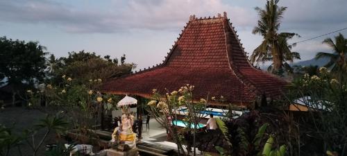 a building with a tile roof and a swimming pool at D'kailash Retreat in Singaraja