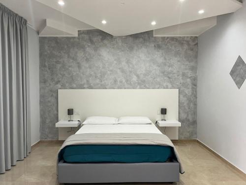 1 dormitorio con 1 cama grande y 2 mesas blancas en Agri-Resort Luxury Farm, en Marigliano
