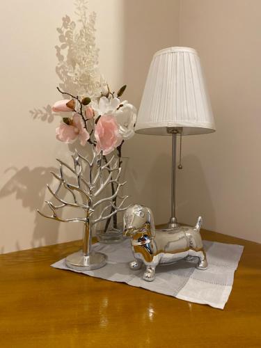 a table with a lamp and a toy elephant and flowers at Inalda in Ełk