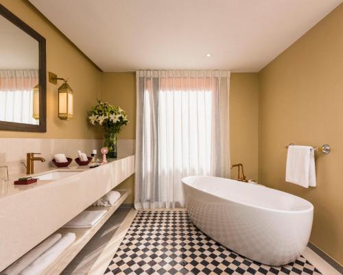 a bathroom with a large tub and a sink at Berbère Palace in Ouarzazate